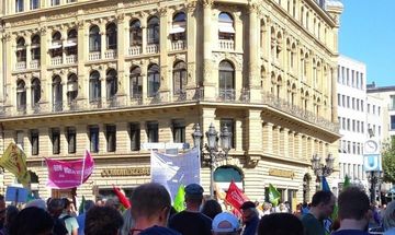 Menge am Opernplatz mit Demoschildern