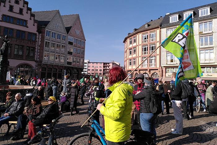 BUND KV Geschäftsstellenleitung mit BUND Fahne und Fahrrad auf dem Römerplatz in Frankfurt zwischen anderen Demonstranten.